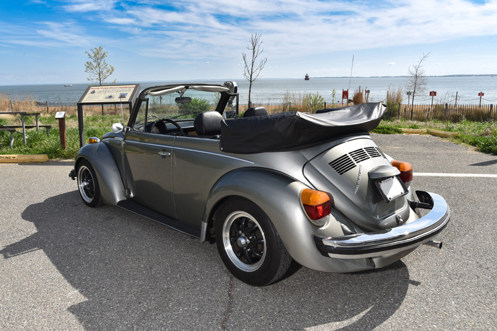 1979 Volkswagen Super Beetle convertible parked by the waterfront with the top down