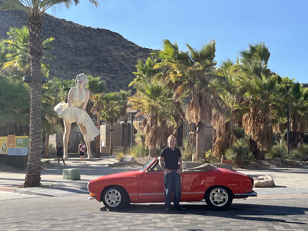 Danny Bonaduce standing beside his red Karmann Ghia near the Marilyn Monroe statue in downtown Palm Springs