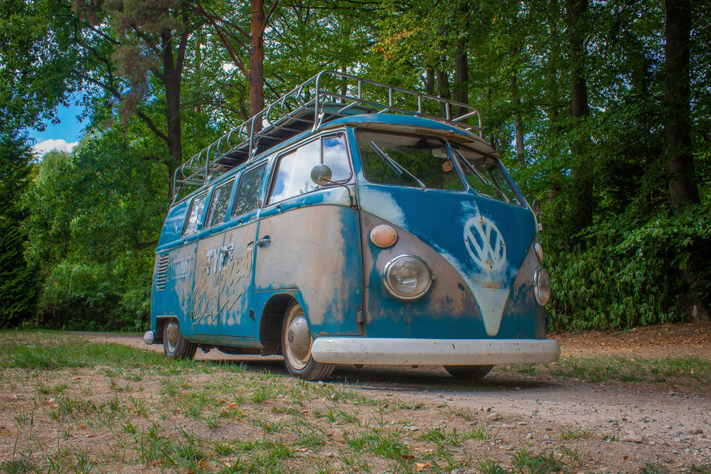 Weathered Volkswagen Bus on a forest path, showing original air cooled Type 2 styling