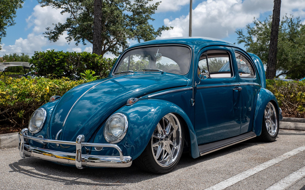 Lowered blue Volkswagen Beetle with custom wheels, highlighting classic air cooled styling