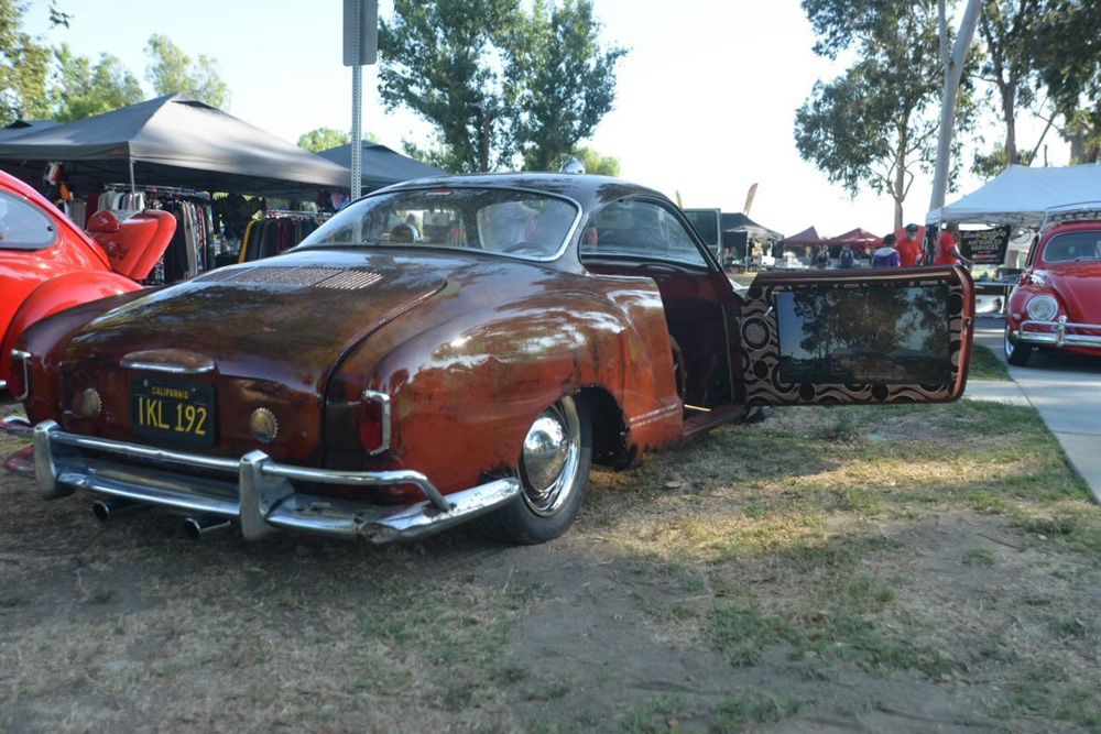 Patina Volkswagen Karmann Ghia with open door and custom interior panel at the El Prado VW Show & Shine