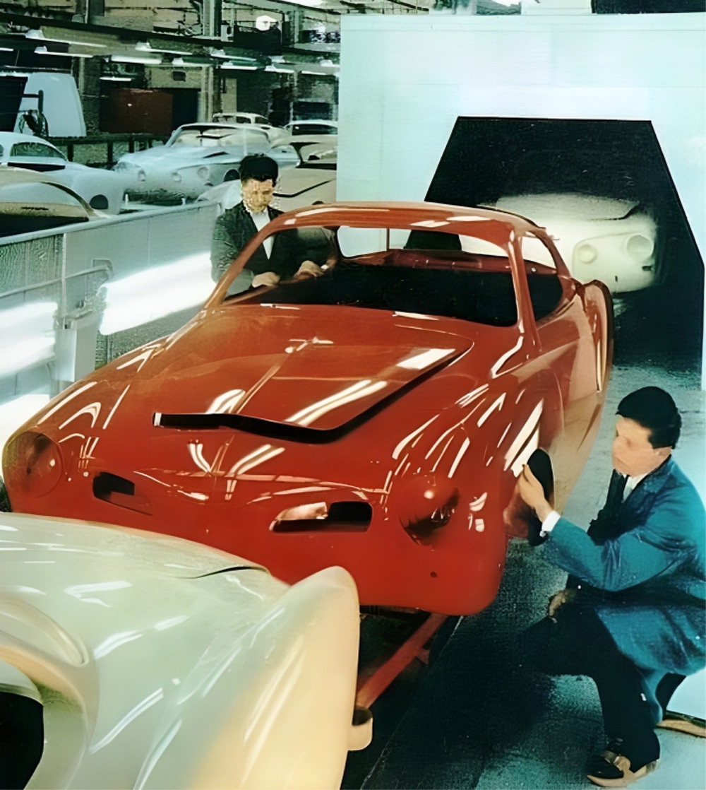 A Type 14 Karmann Ghia body on the paint line at the Karmann factory in Osnabruck. A Type 34 Karmann Ghia can be seen behind it, emerging from the tunnel.