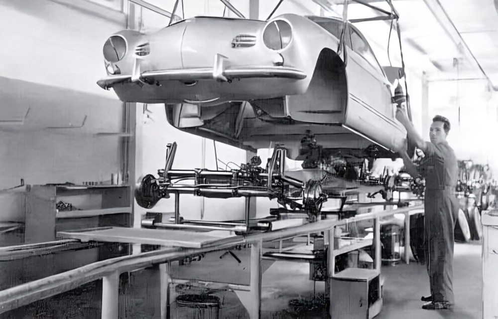 Early Karmann factory photo showing workers marrying a body shell to its chassis in the mid-1950s