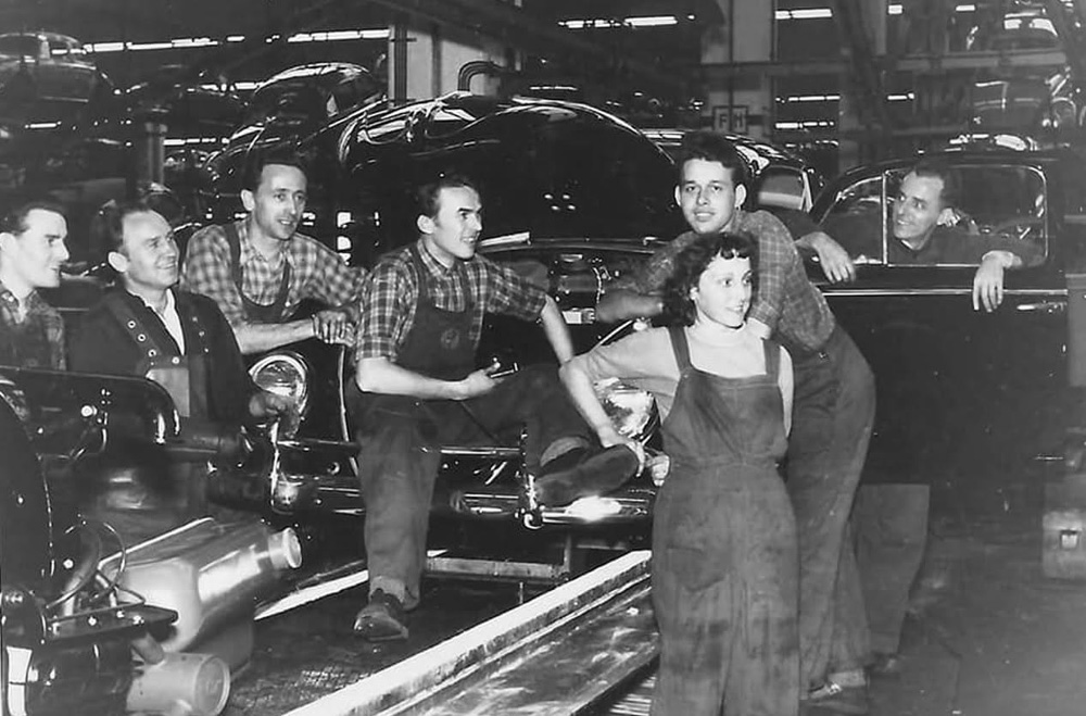 Wolfsburg line workers posing during 1960 Beetle production